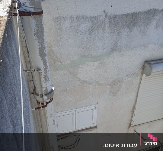 צינור מתכת מחובר לקיר עם חבקים חלודים